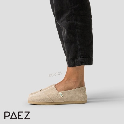 Sapatos alpercata bege com sola clara da marca PAEZ, usados com calças pretas.