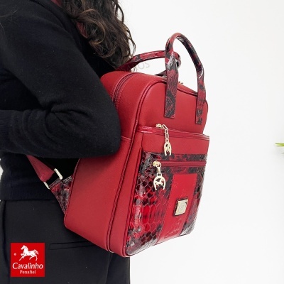 Mochila vermelha com padrão de pele de cobra e fechos dourados