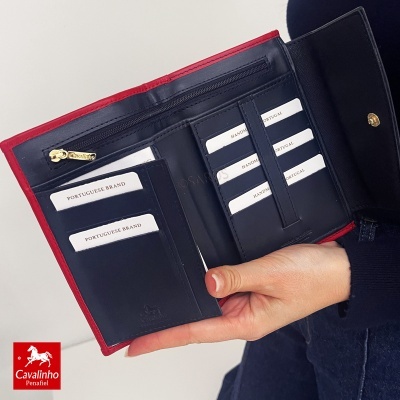 Carteira em pele azul e vermelha com múltiplos compartimentos para cartões e fecho de botão dourado.