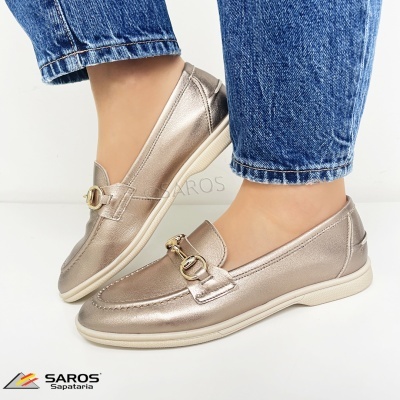 Mocassins dourados metálicos com fivela dourada e sola branca usados com jeans azuis