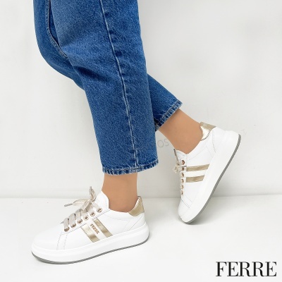 Sapatilhas brancas com detalhes dourados metálicos, calças de ganga azuis, fundo branco