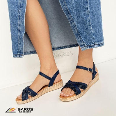 Sandálias azuis escuras com sola tipo espartilho usadas por modelo com calças de ganga