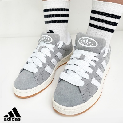 Ténis Adidas cinzentos com riscas brancas e meias brancas com riscas pretas