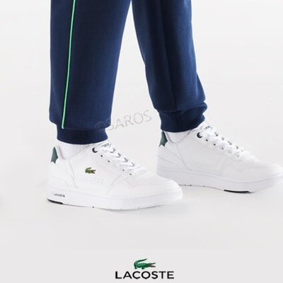 Tênis brancos Lacoste com detalhes verdes e logo de crocodilo à lateral