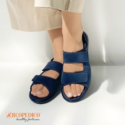 Sandálias azuis escuras com dois velcros e sola preta em fundo branco.