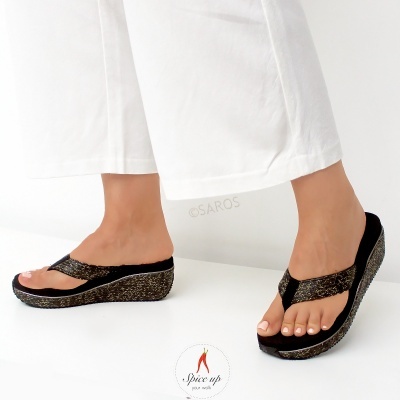 Sandálias pretas com cunha dourada em fundo branco