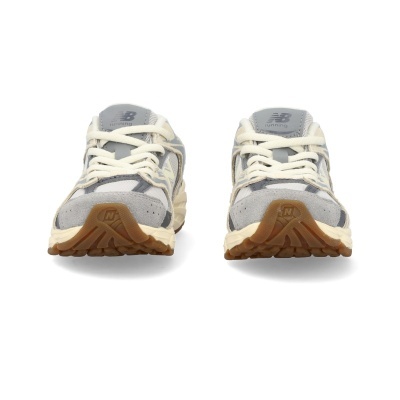 Par de sapatilhas New Balance cinza e bege no fundo branco