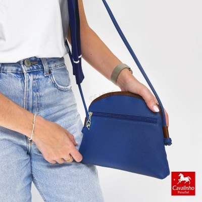 Mala de ombro azul com fecho zip prateado e detalhes castanhos