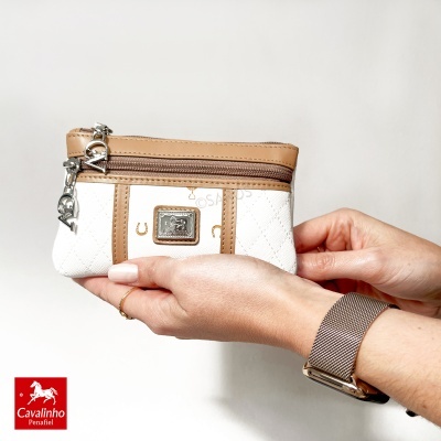 Carteira Cavalinho pequena branca e bege nas mãos