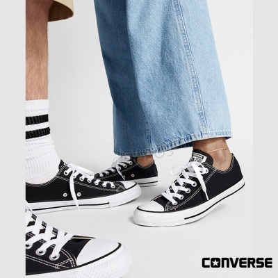 Tênis Converse All Star pretos com sola branca em fundo branco
