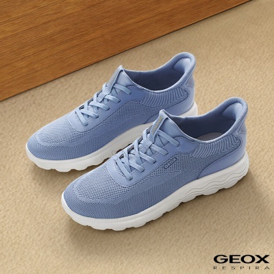 Sapatilhas azuis com sola branca e marca GEOX em superfície bege