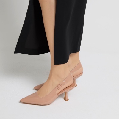 Sapatos de salto médio cor de pele com tiras laterais e saia preta