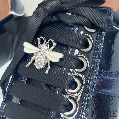Sapatilha preta com verniz e broche de abelha com strass e asas brancas nos atacadores