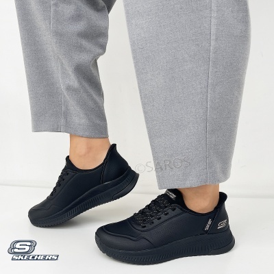 Ténis pretos Skechers usados com calças cinzentas