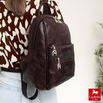 Mochila Cavalinho em pele castanha escura com padrão de cavalos em relevo e fechos metálicos em ferradura