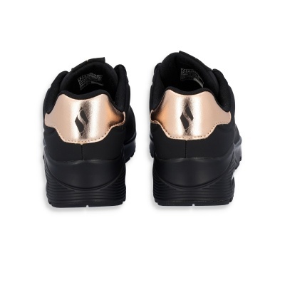 Tênis pretos com detalhes em bronze metálico vistos de trás