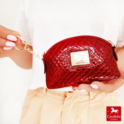 Mala pequena vermelha com textura de pele de crocodilo e placa dourada