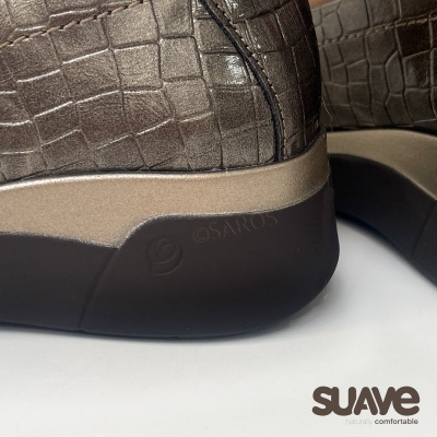 Sapatilhas castanhas com padrão pele de crocodilo e sola preta e bege, logótipo SAROS na sola e marca SUAVE no fundo.