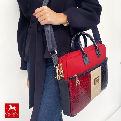 Mala feminina com padrão pele de cobra em cores vermelho, bege e azul escuro e detalhes dourados