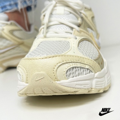 Ténis Nike bege e branco com diferentes texturas e pequeno logo na sola