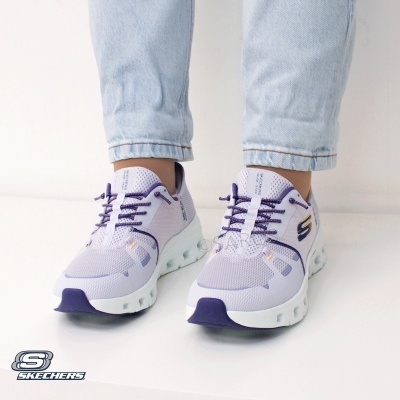 Ténis Skechers lilás com detalhes roxos e sola branca usados com calças de ganga claras