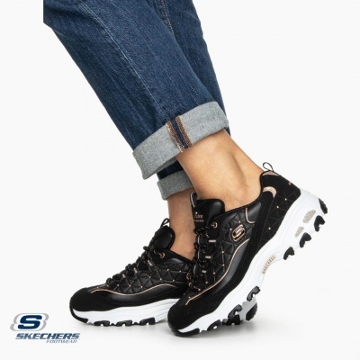 Ténis Skechers pretos com sola branca usados com calças de ganga