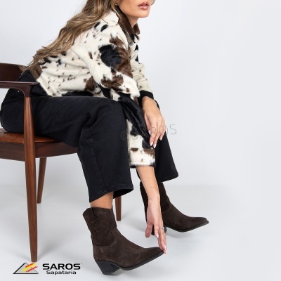 Bota camurça castanha estilo cowboy com salto baixo em ambiente branco