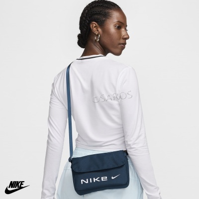 Bolsa Nike azul escuro com logotipo branco, usada por pessoa com blusa branca
