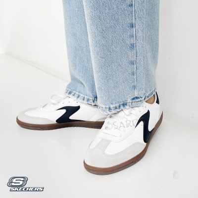 Ténis brancos Skechers com detalhes cinza e pretos, e calças de ganga azul claro