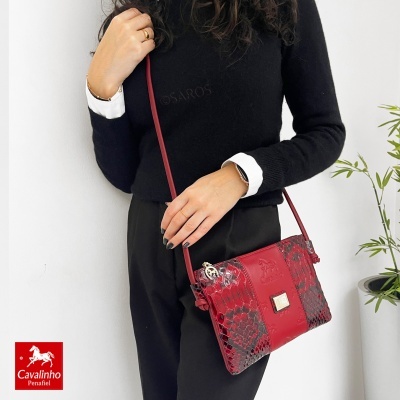 Mala de tiracolo vermelha com padrão de escamas em pele e detalhes em relevo