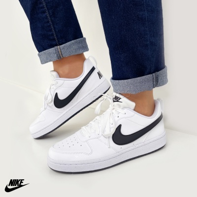 Ténis Nike brancos com Swoosh preto e sola branca usados com calças de ganga azul