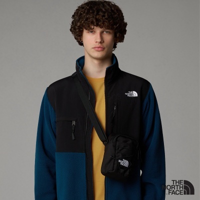 Casaco de fleece azul e preto da The North Face com mochila preta pequena