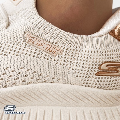Ténis Skechers slip-ons bege claro em tecido tricotado com sola branca e detalhes dourados
