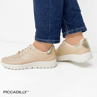 Sapatilhas nude com detalhe dourado e sola branca, usadas com calças de ganga