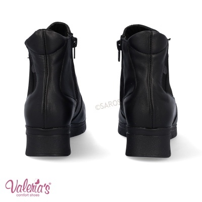 Botas pretas de couro com fecho lateral e salto baixo vistas de trás
