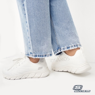 Ténis Skechers brancos com sola branca usados com calças de ganga claras