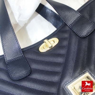 Mala preta de couro com fecho dourado e etiqueta Cavalinho Penafiel