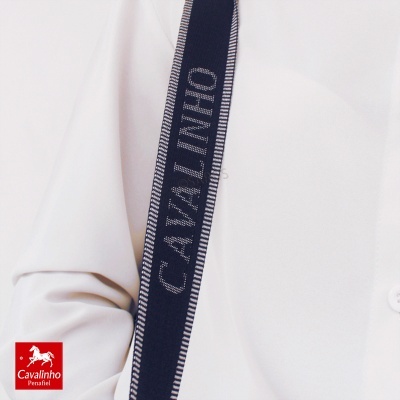 Fita azul escuro com texto CAVALINHO sobre camisa branca