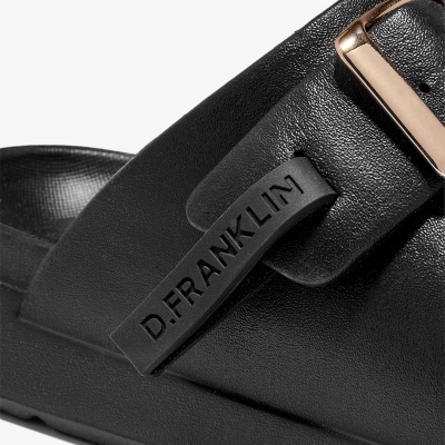 Sandália preta com fivela dourada e tira com texto D.FRANKLIN