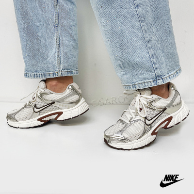 Ténis Nike branco e cinzento usados com calças de ganga azul