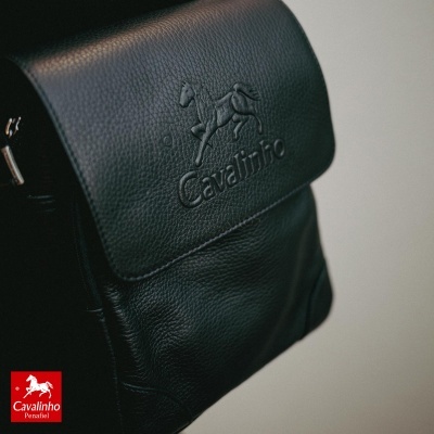 Mala preta em pele com relevo de cavalo e texto Cavalinho