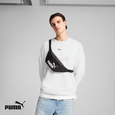 Homem com sweatshirt branca, jeans azuis e bolsa tiracolo preta PUMA