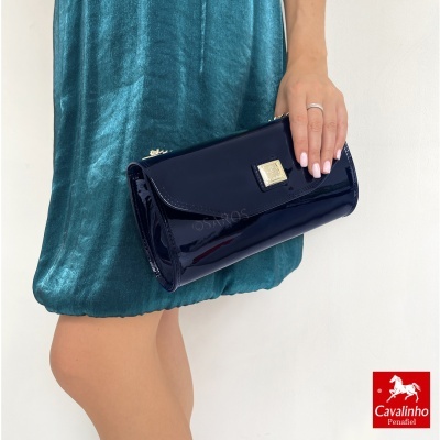 Carteira azul verniz com fecho dourado e vestido azul esverdeado