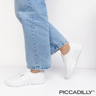 Ténis brancos com sola branca usados com calças de ganga azul clara