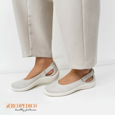 Sapatilhas brancas com padrão e sola branca usadas com calças bege claras