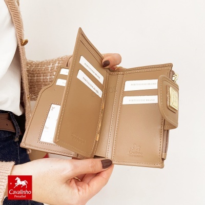 Carteira castanha de pele genuína com vários compartimentos para cartões aberta, mostrando etiquetas da marca Cavalinho.