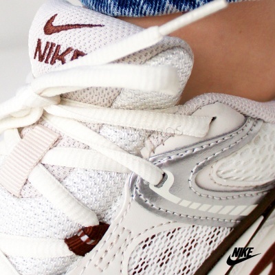 Tênis desportivo Nike branco com detalhes em castanho e cinzento
