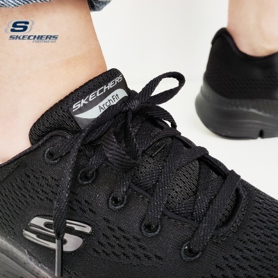 Ténis pretos Skechers Arch Fit vistos de perto com atacadores e logótipo prateado
