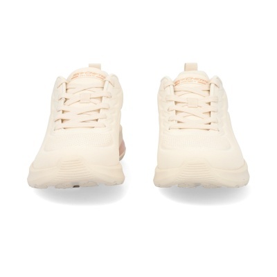 Tênis esportivos bege claro em fundo branco.