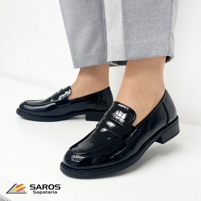 Sapatos mocassins pretos em verniz usados com calças cinzentas